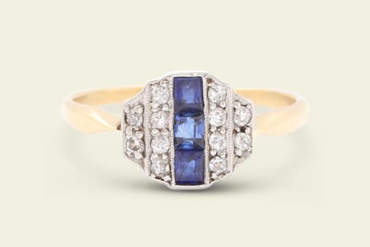 Erica Weiner Art Deco sapphire and diamond ring with a column of sapphires flanked by lines of old European cut diamonds. The mounting features a minimal, low gallery, pointed shoulders, and a slender half round hoop. (Photo courtesy of Erica Weiner)