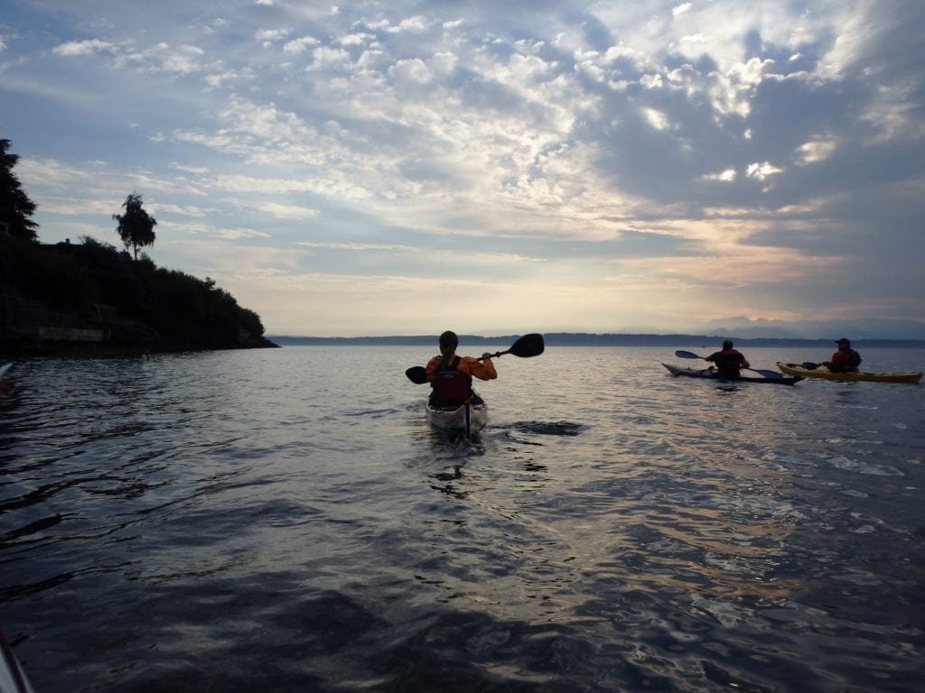 Kayakers on Puget sound admire the sunset