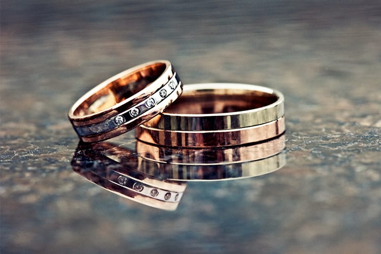 Metal wedding bands on a shiny surface