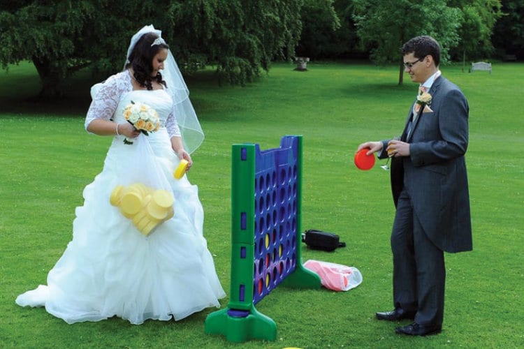 A newlywed couple plays an oversize version of Connect Four