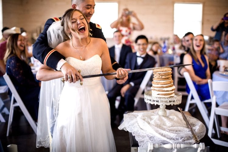 A couple "cut" their wedding cake with a sword