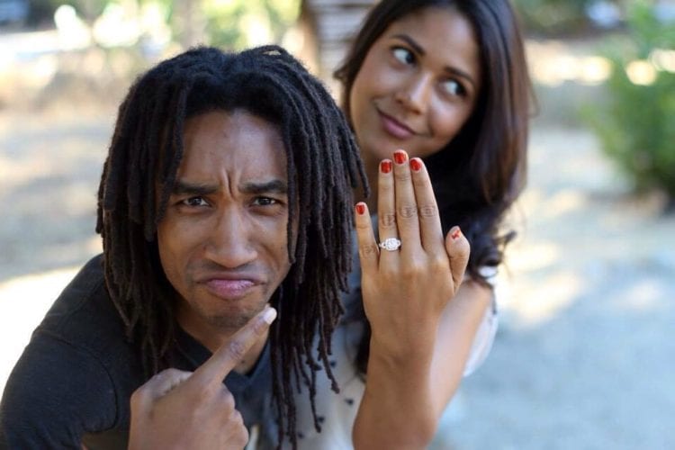 A guy mugs for the camera while his fiance shows off her engagement ring.